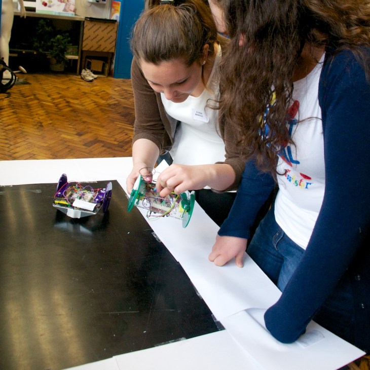 Two RoboSlam participants testing the performance of their robots.